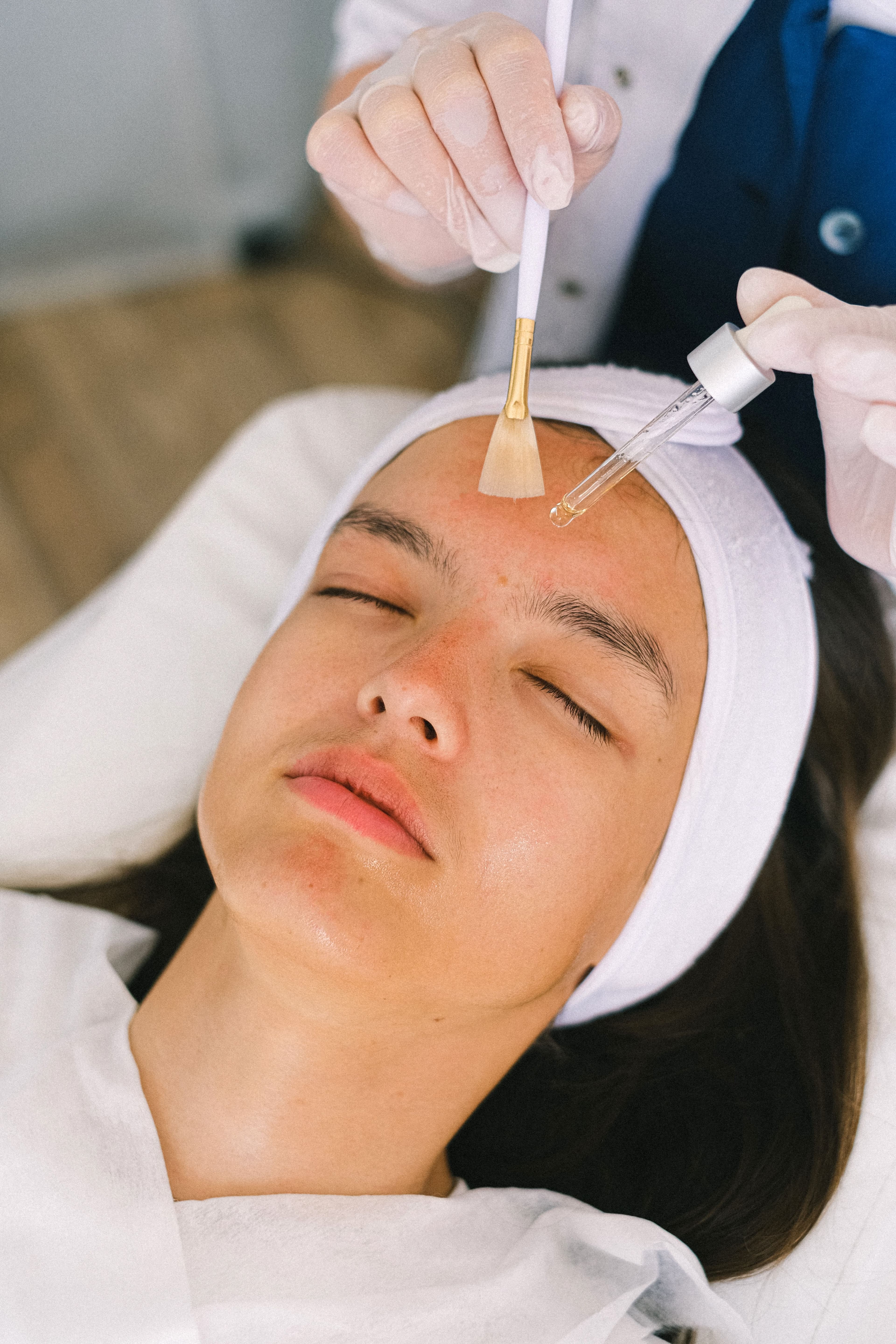 A facial in progress, with a treatment applied to the skin using a brush.